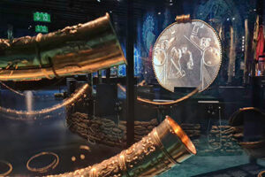 Projection mapping af animeret guldsmykke med guldhornene i forgrunden.