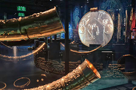 Projection mapping af animeret guldsmykke med guldhornene i forgrunden.